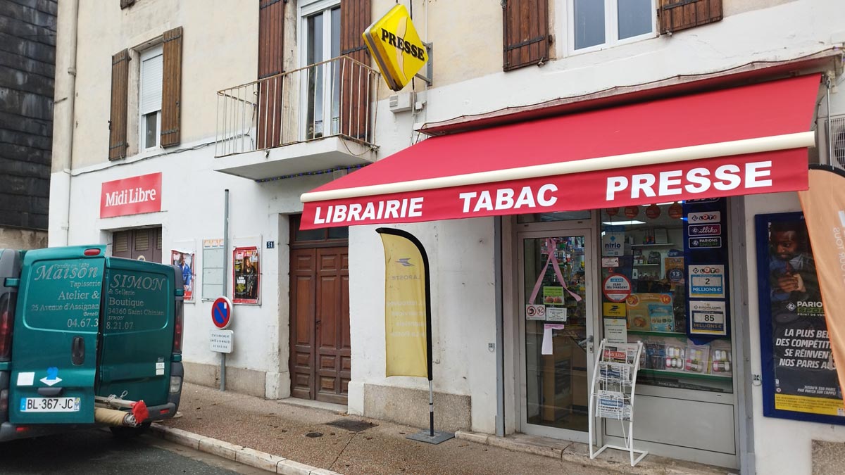 Rentoilage d'un store à banne manuel chez Librairie Presse Loto - Faure-Vincent à Saint-Pons-de-Thomières (34)